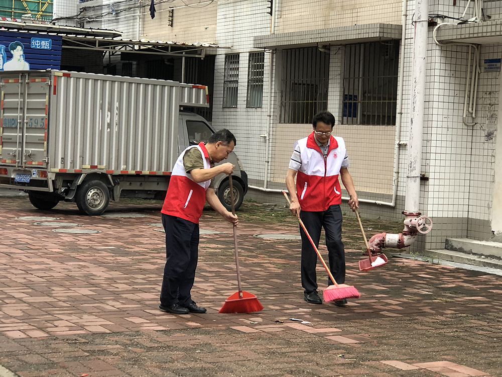 照片3：学校党总支书记、副校长沈小明带领党员志愿者对校园垃圾进行清理